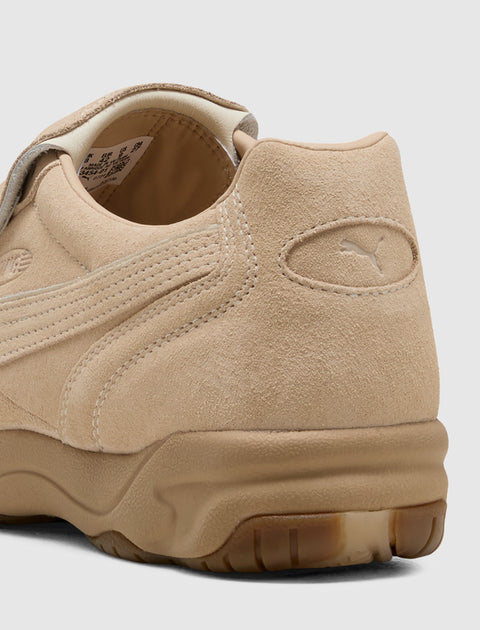 Close-up of beige suede men's sneaker with textured sole and visible side stitching