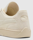 Close-up of beige suede and leather sneaker heel with embossed logo detailing