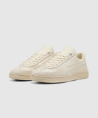 Beige low-top sneakers with suede and leather panels on a white background