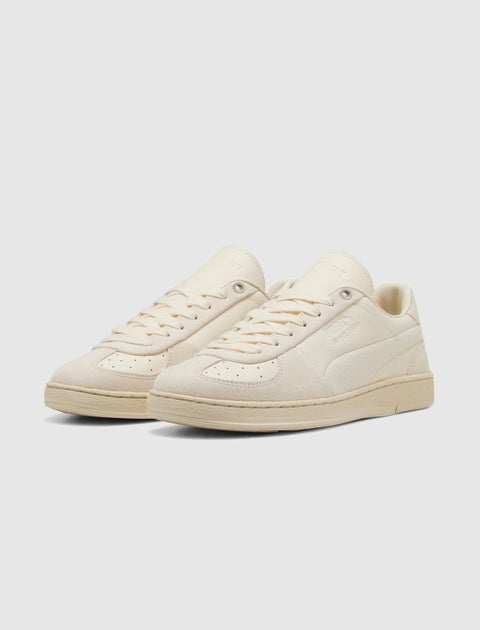 Beige low-top sneakers with suede and leather panels on a white background
