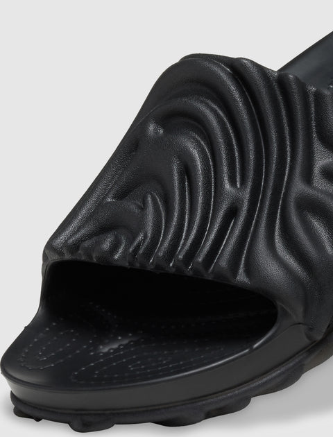 Black textured slide sandal with sculpted upper and open toe on a white background