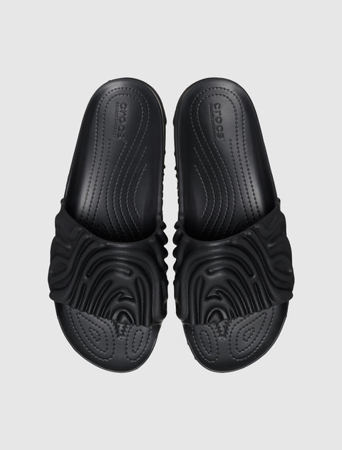 Black sculpted slides with textured strap and contoured footbed on a light background