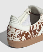 Close-up of sneaker with brown and white cow print pattern and gum rubber sole