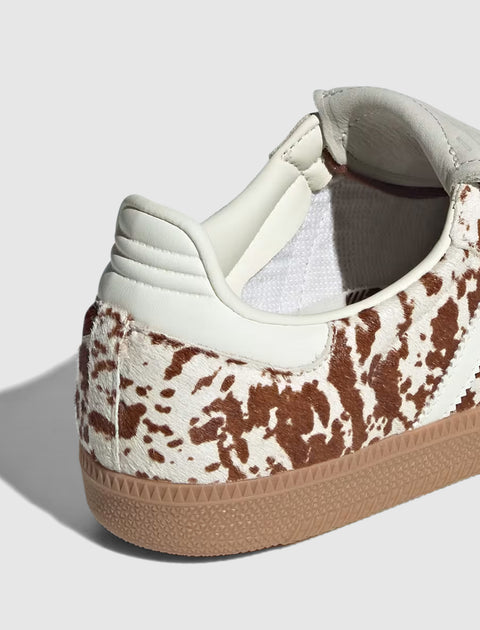 Close-up of sneaker with brown and white cow print pattern and gum rubber sole