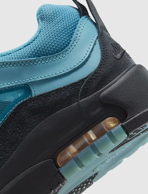 Close-up of blue and black sneaker with mesh upper, suede accents, and visible air sole unit