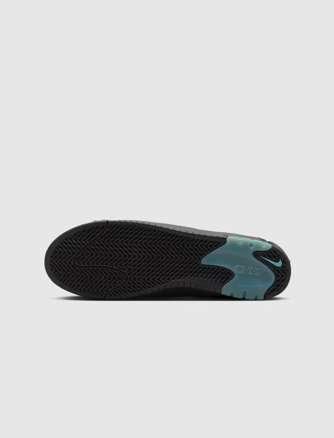 Black sneaker outsole with turquoise detailing and textured grip pattern