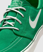 Close-up of green suede skate shoe with white Nike Swoosh and white laces
