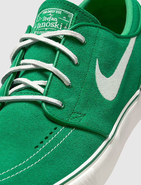 Close-up of green suede skate shoe with white Nike Swoosh and white laces