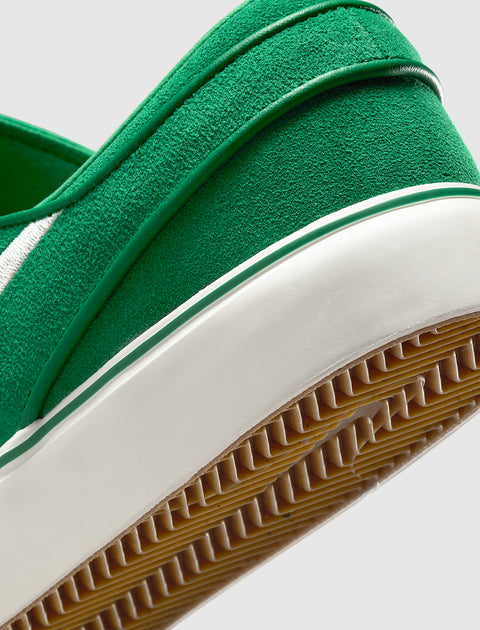 Closeup of green suede sneaker heel with white midsole and textured gum sole