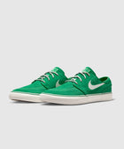 Green low-top sneakers with white laces and white swoosh logo on side, casual streetwear shoes