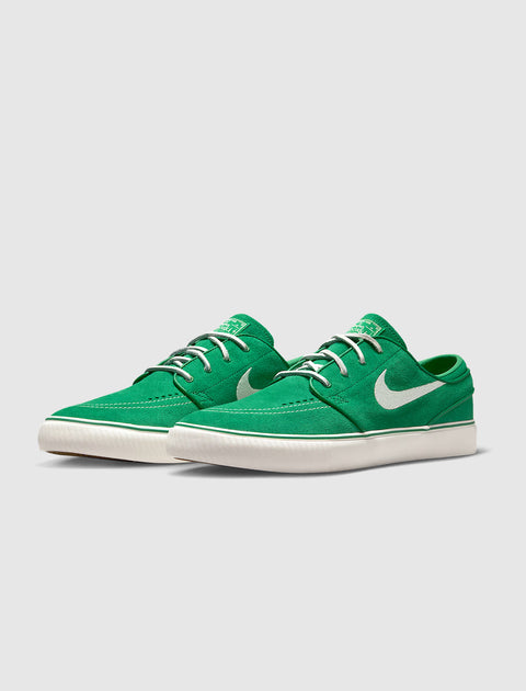 Green low-top sneakers with white laces and white swoosh logo on side, casual streetwear shoes