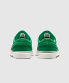 Back view of green suede low-top sneakers with white soles on gray background