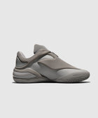 Side view of a gray low-top sneaker with sculpted sole and minimalist design