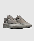 Minimalist grey slip-on sneakers with a sculpted sole, side view on light background.