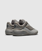 Gray low-top sneakers with a sleek, futuristic design and textured sole, viewed from the back