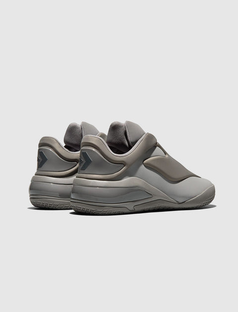 Gray low-top sneakers with a sleek, futuristic design and textured sole, viewed from the back