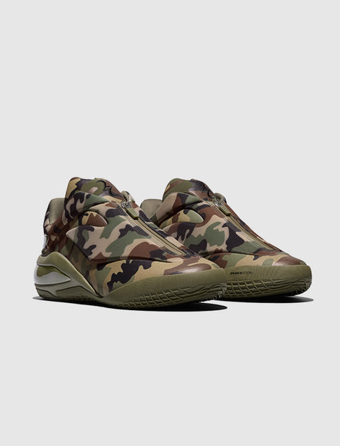 Men's sneakers with green camo print, side zip detail, and chunky sole on gray background