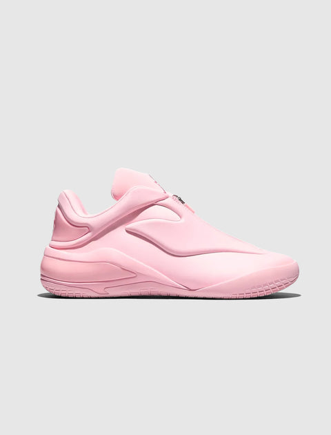 Pink low-top sneaker with futuristic design and molded rubber sole on grey background
