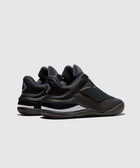 black low-top slip-on sneakers with rubber soles and white accents, rear view