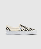 Black and white checkerboard slip-on sneaker with white sole on a plain background