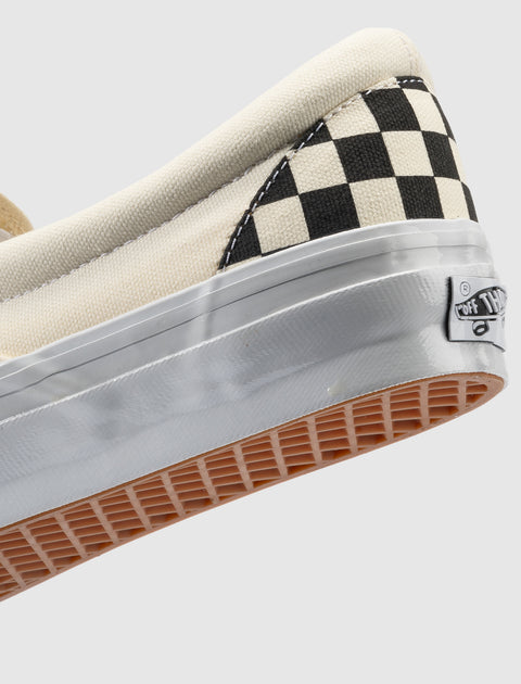 Close-up of slip-on sneaker with black and white checkerboard pattern and waffle sole