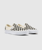 Black and white checkerboard slip-on sneakers with white soles on a plain background