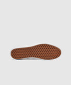 Brown waffle-pattern rubber sole of a slip-on sneaker on a light background