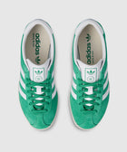 Top view of green and white suede low-top sneakers with white stripes and logo details.