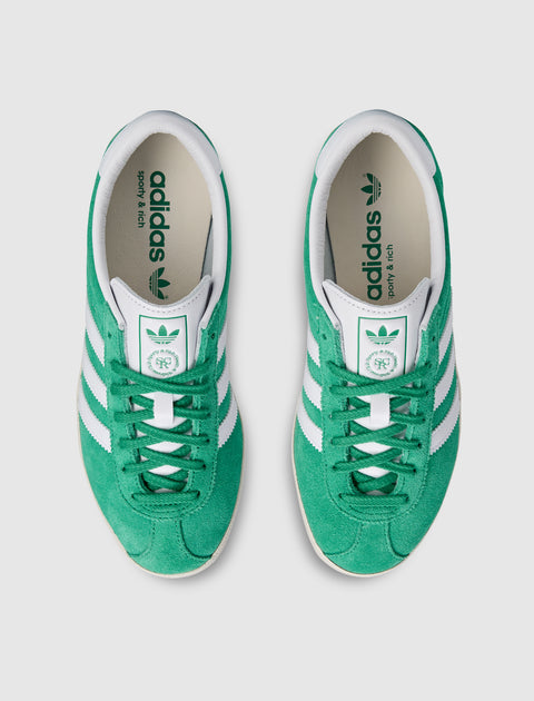 Top view of green and white suede low-top sneakers with white stripes and logo details.