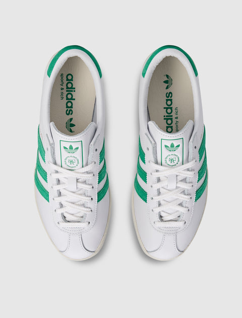 White and green low-top sneakers with green stripes and branded insoles, top view