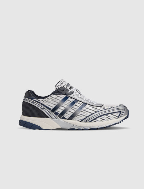 White and navy athletic sneaker with mesh upper and dark blue stripes, side view
