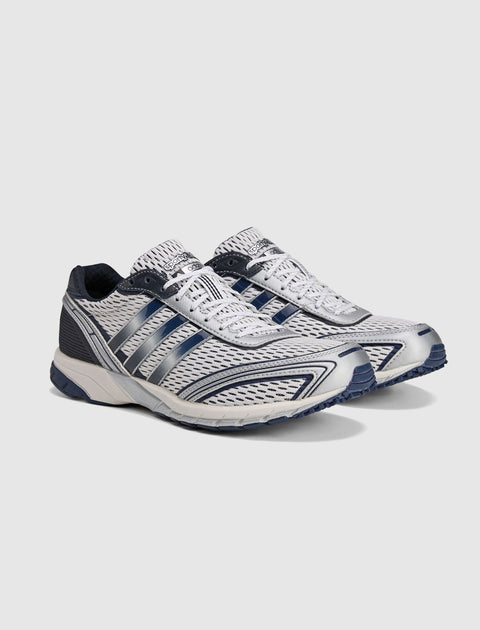 White and navy athletic sneakers with mesh upper and dark blue accents on a plain background