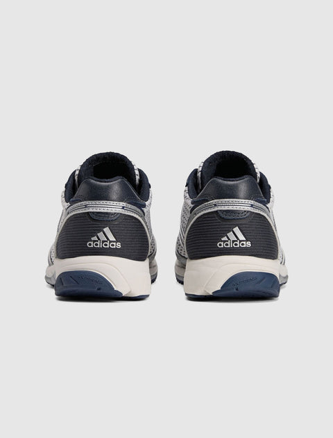 Rear view of white and navy Adidas running sneakers with mesh uppers and logo on heels