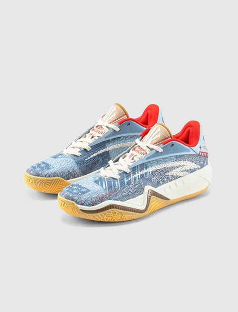 Blue patterned low-top sneakers with cream laces, red lining, and gum soles on a gray background