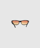 Black frame sunglasses with gradient orange tinted lenses on a plain background