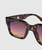 Close-up of tortoiseshell sunglasses with square frames and gradient brown lenses