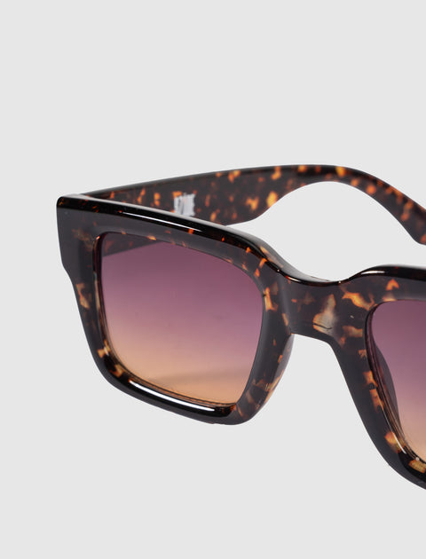 Close-up of tortoiseshell sunglasses with square frames and gradient brown lenses