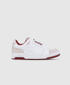 White and beige low-top sneaker with burgundy accents, men's streetwear shoe on white background