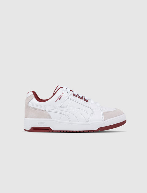 White and beige low-top sneaker with burgundy accents, men's streetwear shoe on white background
