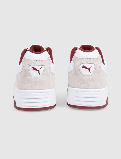 Back view of white and beige suede sneakers with red accents and Puma logo