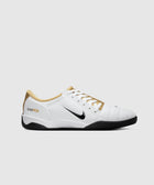 White and gold Nike sneaker with black sole and Total 90 branding, side view on gray background
