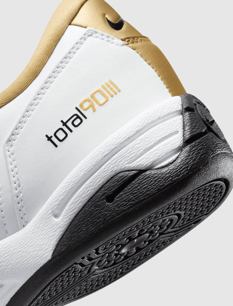 Close-up of white, gold, and black sneaker heel with Total 90 logo and textured sole