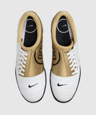 Top view of white and gold Nike sneakers with black logo, lace-up athletic shoes on white background