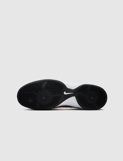 Closeup of black rubber sneaker sole with white and gold accents on a plain background