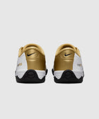 Rear view of white, black, and gold Nike sneakers with logo and total90 lettering