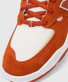 Close-up of orange suede and white mesh sneaker with flat laces and white rubber sole