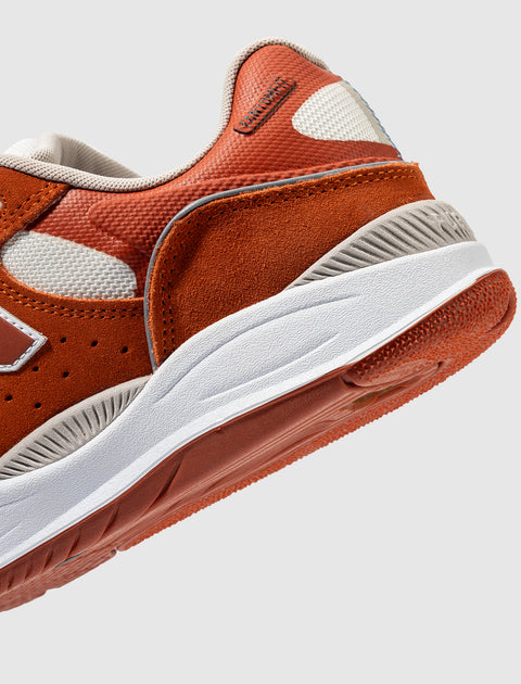 Close-up of orange and white men's streetwear sneaker with suede and mesh details