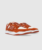 Rust orange and white low-top sneakers with suede and mesh upper, side N logo