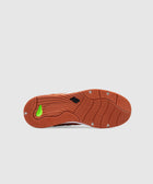 Rust-colored sneaker outsole with textured grip and New Balance logo on white background