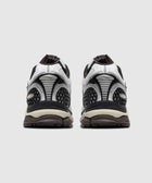 Rear view of white and black athletic sneakers with mesh and textured detailing